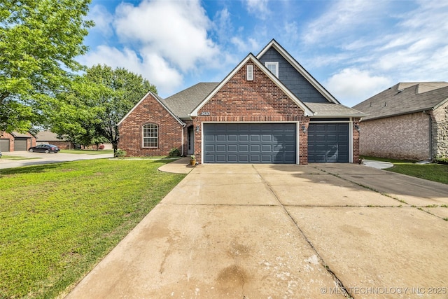 traditional-style house featuring a shingled roof, brick siding, a garage, a front yard, and concrete driveway