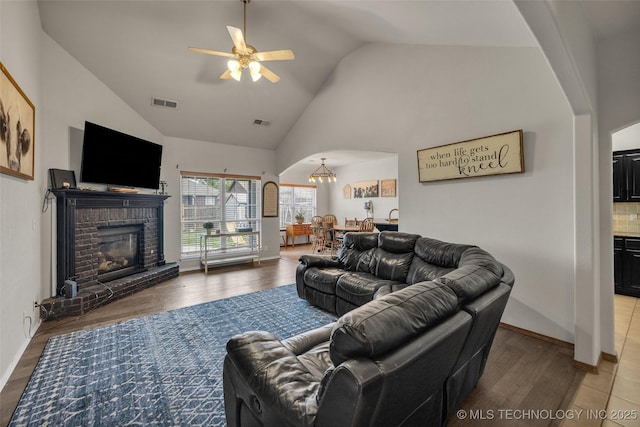 living area featuring arched walkways, a ceiling fan, visible vents, and wood finished floors