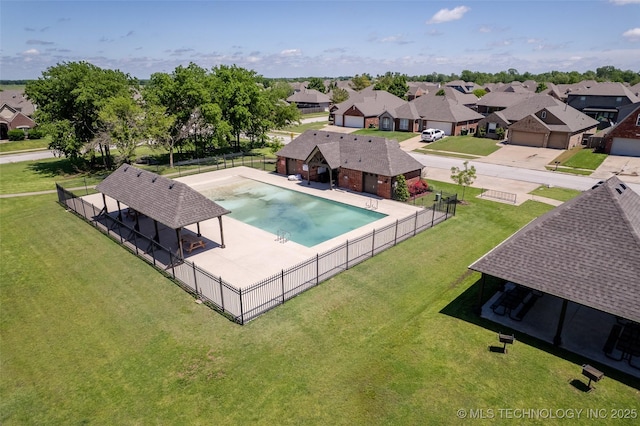 view of pool with a residential view, fence, and a yard