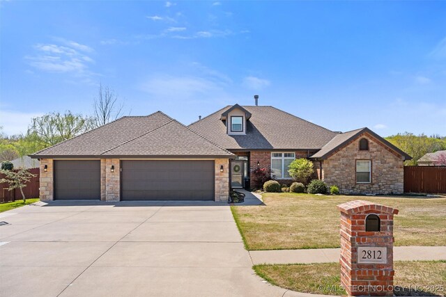 view of front of house featuring concrete driveway, a front lawn, stone siding, and a garage