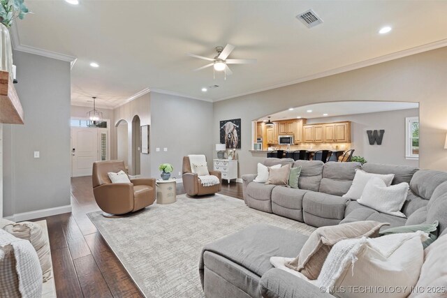 living area featuring arched walkways, a ceiling fan, recessed lighting, and visible vents