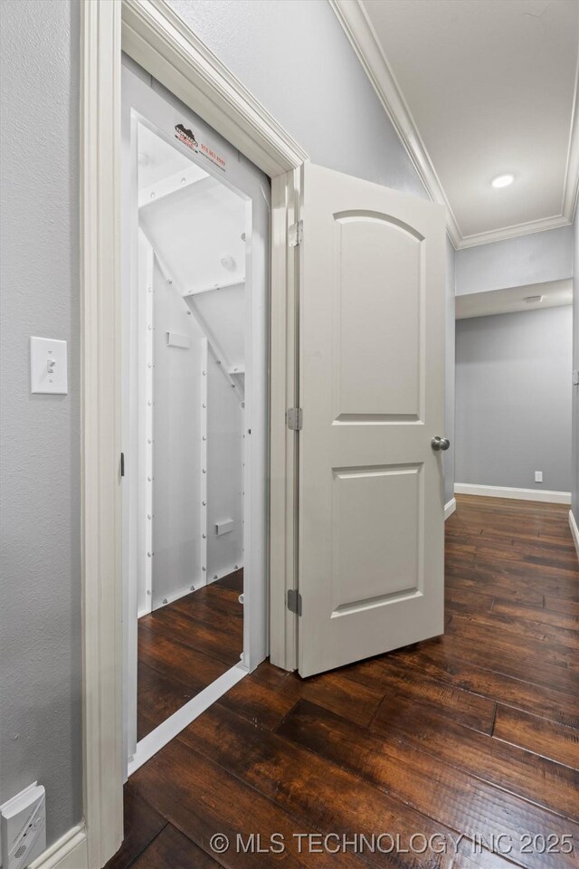 hall with baseboards, ornamental molding, and hardwood / wood-style floors