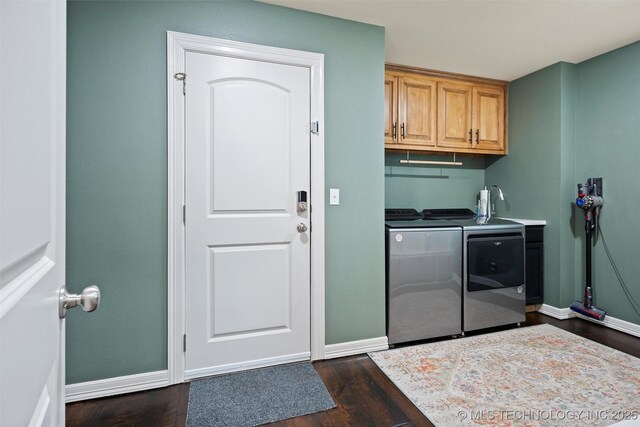 laundry area featuring baseboards, cabinet space, dark wood-style flooring, and washing machine and dryer
