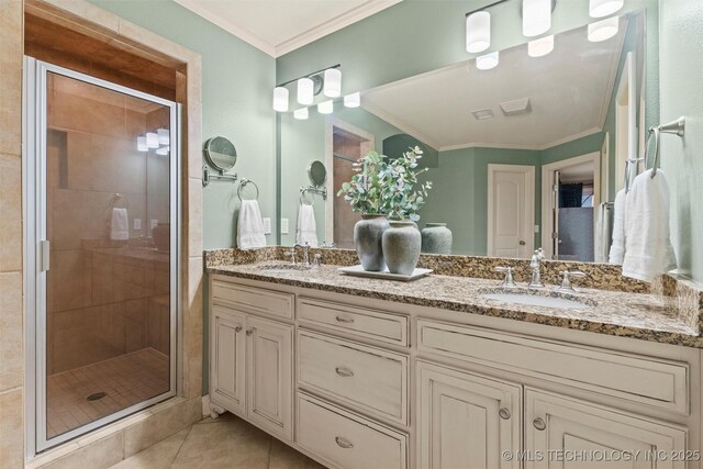 bathroom with a sink, tile patterned flooring, ornamental molding, and a stall shower