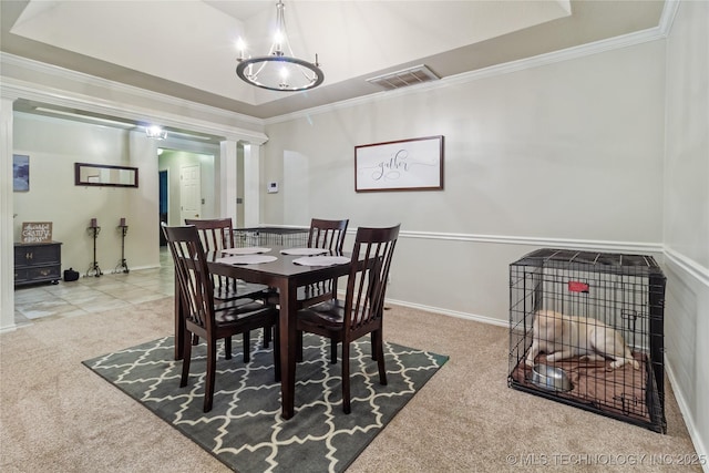 dining room featuring visible vents, crown molding, carpet, a tray ceiling, and ornate columns