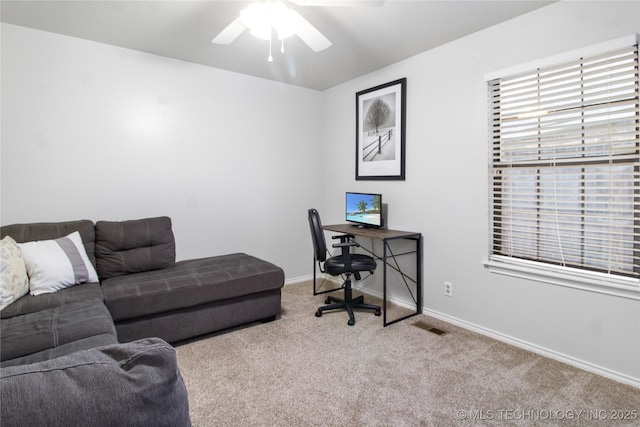 carpeted office space featuring ceiling fan, visible vents, and baseboards