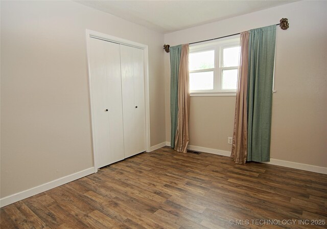 74703 S 320th Rd, Wagoner, OK 74467 - unfurnished bedroom with baseboards, a closet, wood finished floors, and visible vents