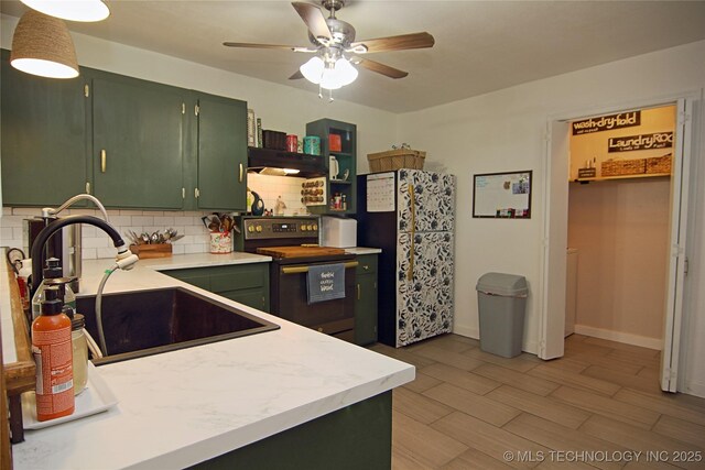 74703 S 320th Rd, Wagoner, OK 74467 - kitchen featuring tasteful backsplash, a sink, green cabinets, freestanding refrigerator, and electric stove