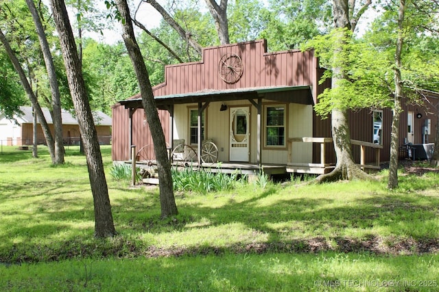 back of property featuring a porch, a lawn, and central AC unit