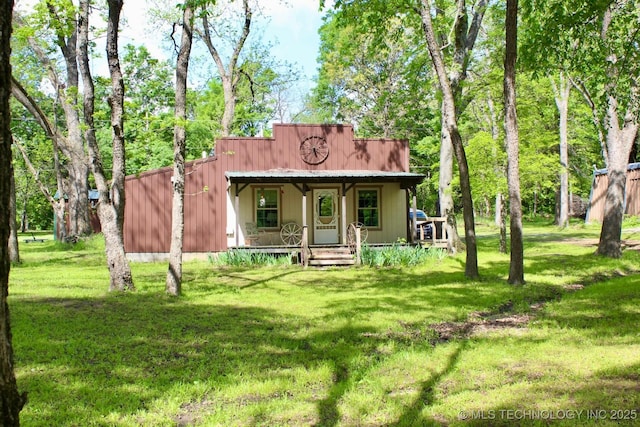 back of house featuring covered porch and a yard