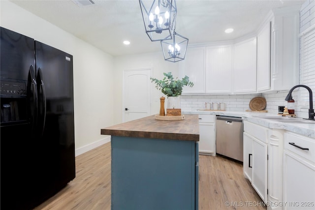 kitchen with a sink, a chandelier, butcher block countertops, black refrigerator with ice dispenser, and stainless steel dishwasher