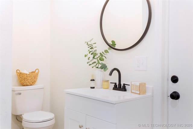 half bath featuring toilet and vanity