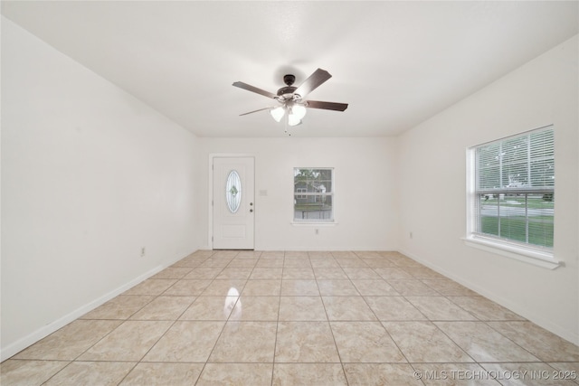 foyer entrance with baseboards, a ceiling fan, and light tile patterned floors