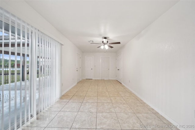 spare room with light tile patterned floors, baseboards, and a ceiling fan