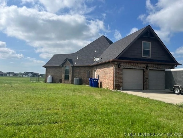 view of side of home featuring a lawn, a garage, driveway, and brick siding