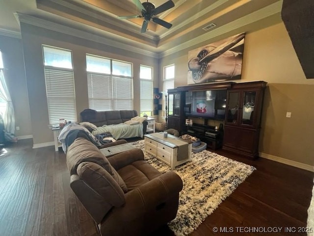 living room featuring ceiling fan, a raised ceiling, ornamental molding, visible vents, and dark wood-style floors