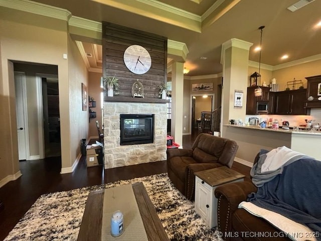 living room with dark wood finished floors, a stone fireplace, baseboards, visible vents, and ornamental molding