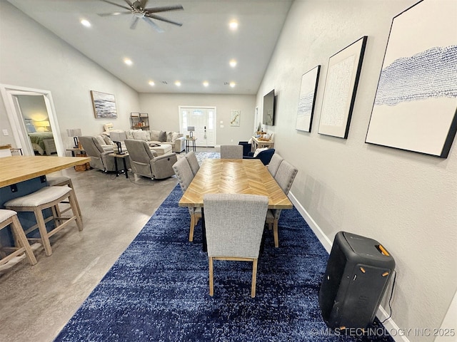 dining room with a ceiling fan, vaulted ceiling, concrete floors, and recessed lighting