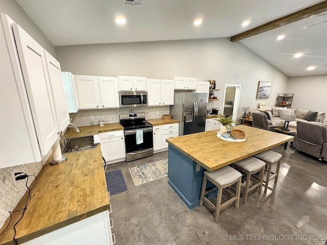 kitchen featuring decorative backsplash, wooden counters, a sink, concrete floors, and appliances with stainless steel finishes
