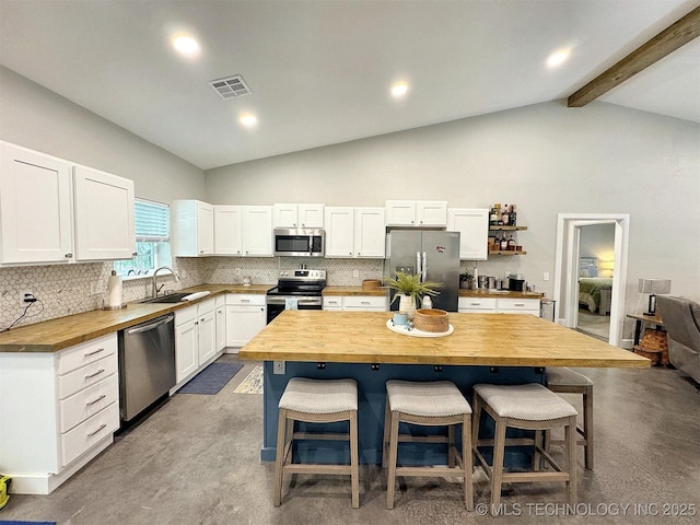 kitchen with visible vents, finished concrete floors, a sink, wood counters, and stainless steel appliances
