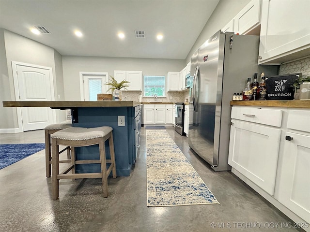 kitchen featuring visible vents, decorative backsplash, finished concrete flooring, a kitchen island, and white cabinetry