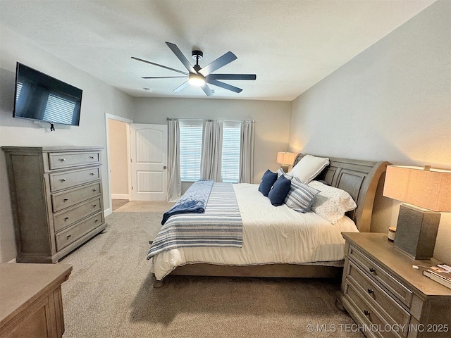 bedroom featuring light carpet and a ceiling fan