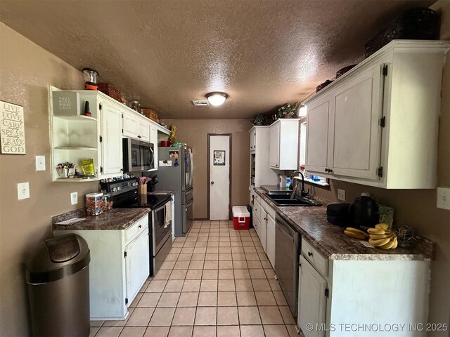 101 E Corporation St, Henryetta, OK 74437 - kitchen with stainless steel appliances, dark countertops, a sink, and a textured ceiling
