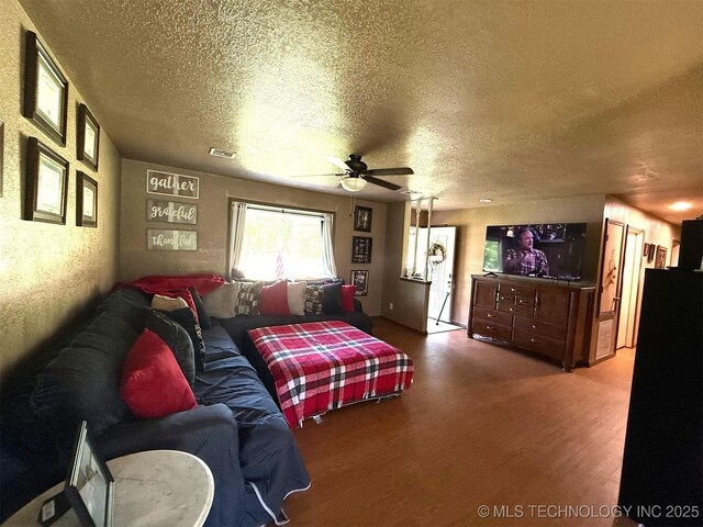 101 E Corporation St, Henryetta, OK 74437 - living room featuring a ceiling fan, a textured ceiling, and wood finished floors