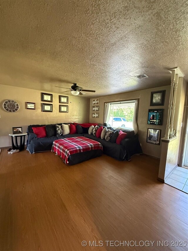 101 E Corporation St, Henryetta, OK 74437 - living area featuring visible vents, a ceiling fan, a textured ceiling, and wood finished floors