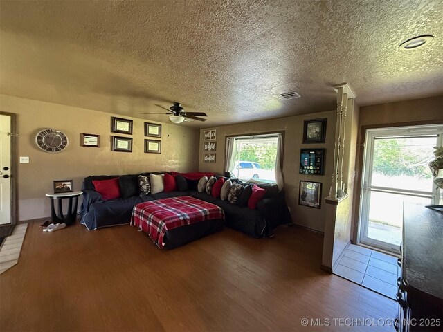 101 E Corporation St, Henryetta, OK 74437 - living room featuring a ceiling fan, a textured ceiling, plenty of natural light, and wood finished floors