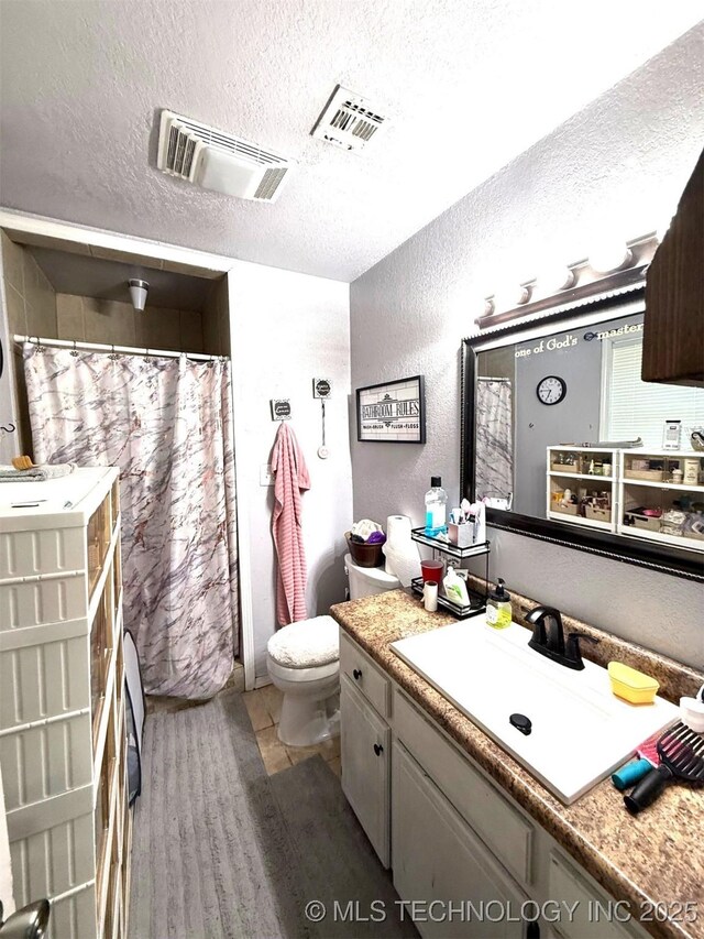 101 E Corporation St, Henryetta, OK 74437 - bathroom with visible vents, a textured ceiling, a textured wall, and toilet