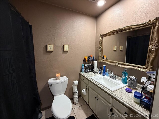 101 E Corporation St, Henryetta, OK 74437 - full bathroom featuring a textured wall, vanity, toilet, tile patterned floors, and a shower with shower curtain