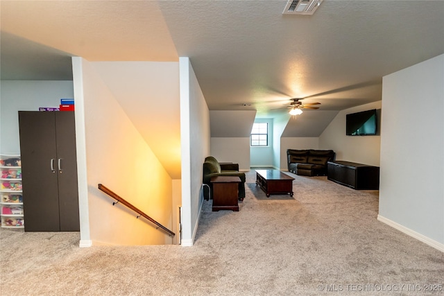 interior space with carpet flooring, a ceiling fan, baseboards, lofted ceiling, and visible vents