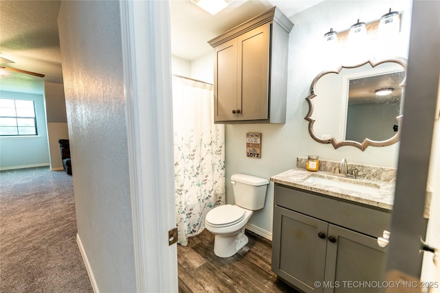 full bath featuring vanity, baseboards, ceiling fan, and toilet