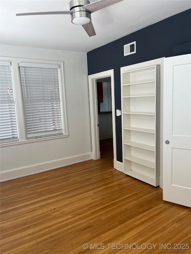 unfurnished bedroom featuring visible vents, a ceiling fan, light wood finished floors, and baseboards