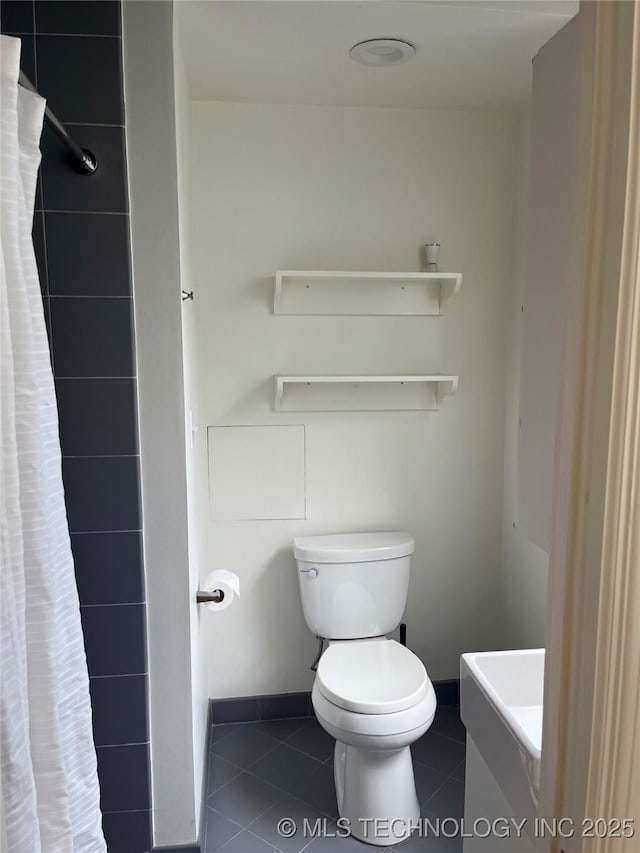 bathroom featuring tile patterned flooring, vanity, curtained shower, toilet, and baseboards