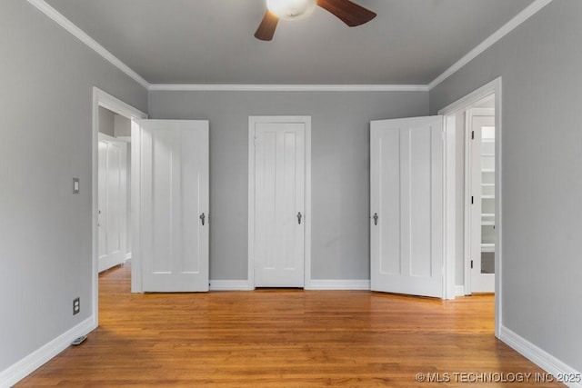 unfurnished bedroom with baseboards, ornamental molding, and wood finished floors