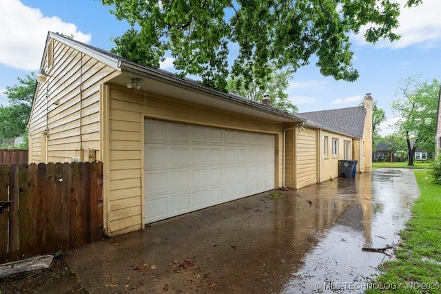 garage featuring fence and driveway