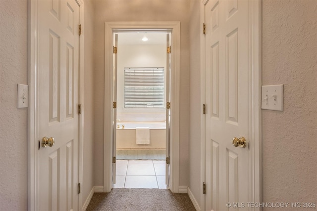 13303 E 95th Pl N, Owasso, OK 74055 - hall with tile patterned floors, a textured wall, and carpet flooring
