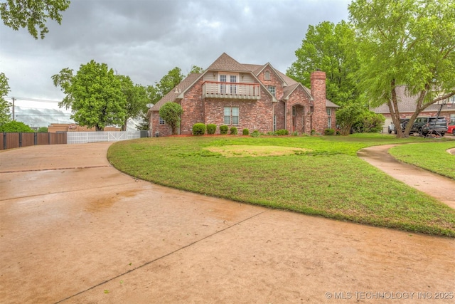 13303 E 95th Pl N, Owasso, OK 74055 - tudor-style house featuring brick siding, fence, a chimney, and a front lawn