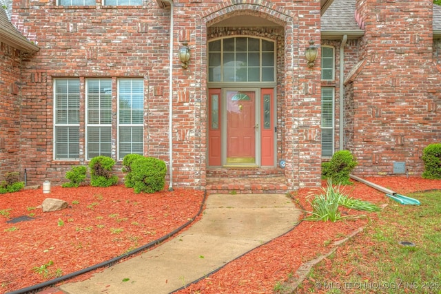 13303 E 95th Pl N, Owasso, OK 74055 - view of exterior entry featuring brick siding and roof with shingles