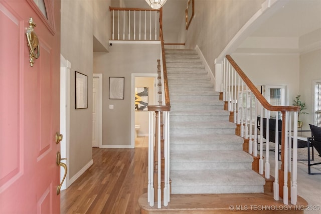 13303 E 95th Pl N, Owasso, OK 74055 - foyer entrance featuring baseboards, stairs, wood finished floors, and a towering ceiling