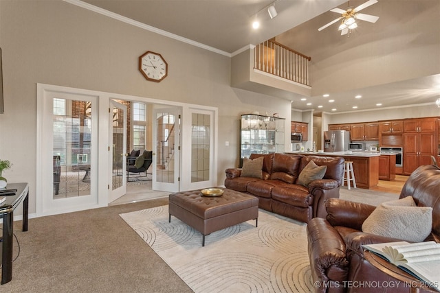 13303 E 95th Pl N, Owasso, OK 74055 - living room with a high ceiling, ceiling fan, light carpet, french doors, and ornamental molding