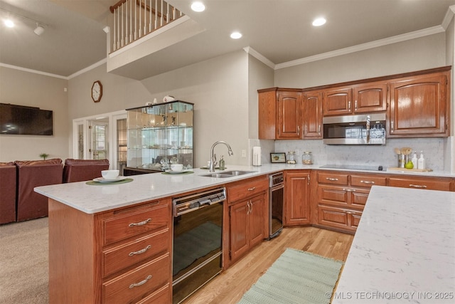 13303 E 95th Pl N, Owasso, OK 74055 - kitchen featuring a sink, a peninsula, open floor plan, ornamental molding, and black appliances