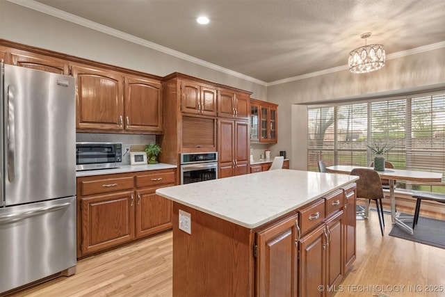 13303 E 95th Pl N, Owasso, OK 74055 - kitchen featuring brown cabinets, light wood finished floors, a center island, stainless steel appliances, and pendant lighting