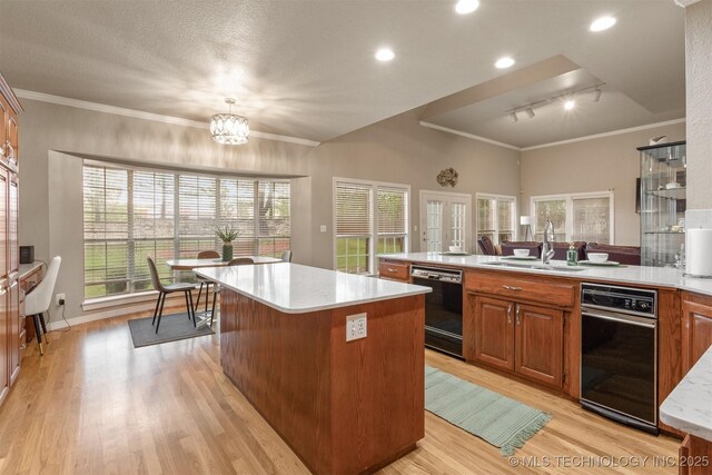 13303 E 95th Pl N, Owasso, OK 74055 - kitchen with a sink, a center island, black dishwasher, and light countertops