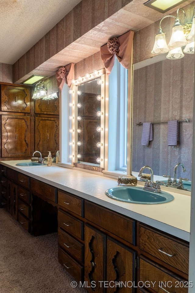 full bath with a textured ceiling, wallpapered walls, and vanity