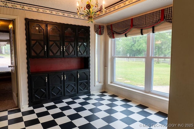 foyer entrance with an inviting chandelier, baseboards, and tile patterned floors