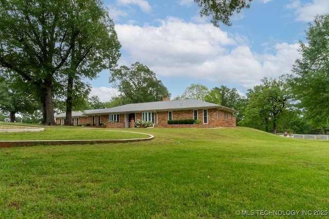 single story home featuring brick siding, fence, a chimney, and a front lawn