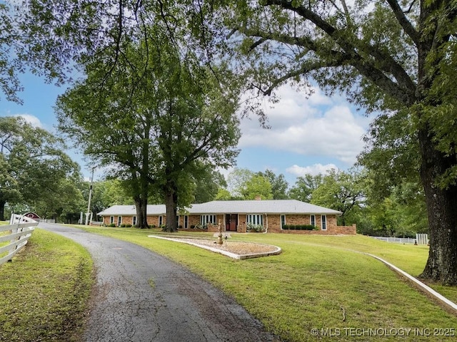view of front of property with fence, a chimney, a front lawn, and brick siding